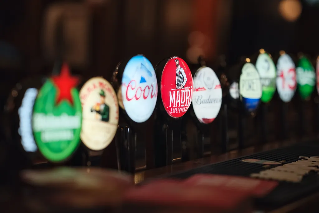 Close-up of illuminated tap badges along the bar, softly out of focus